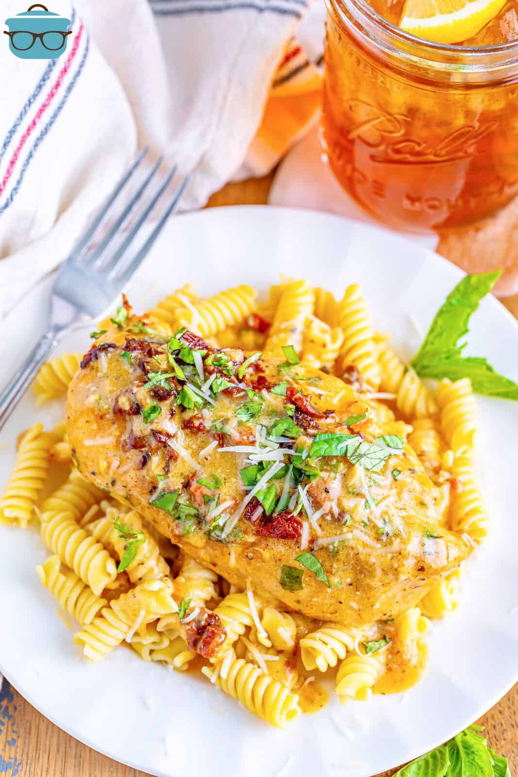 Marry Me Chicken over a bed of pasta on a plate. 