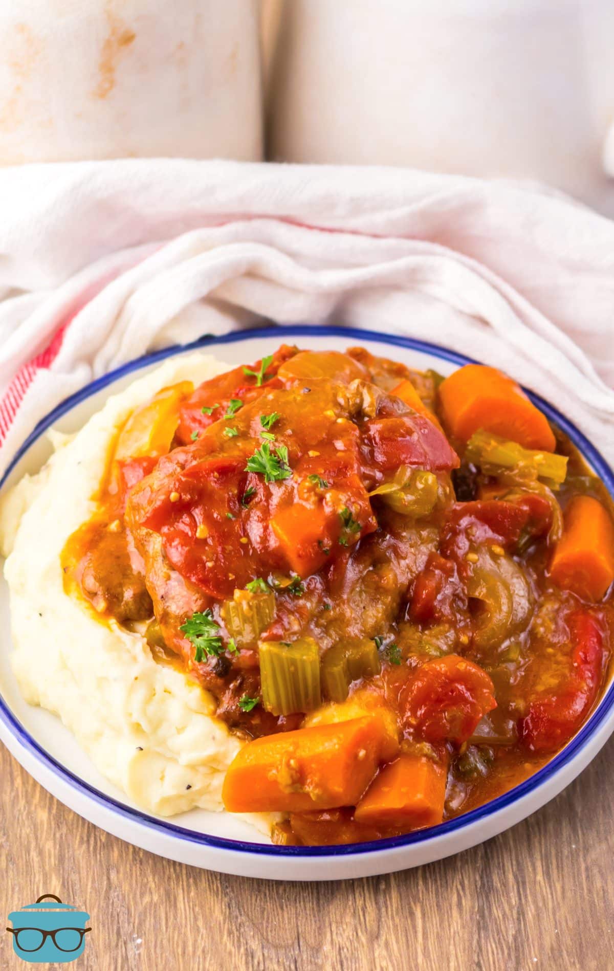A plate of mashed potatoes and Crock Pot Swiss Steak. 