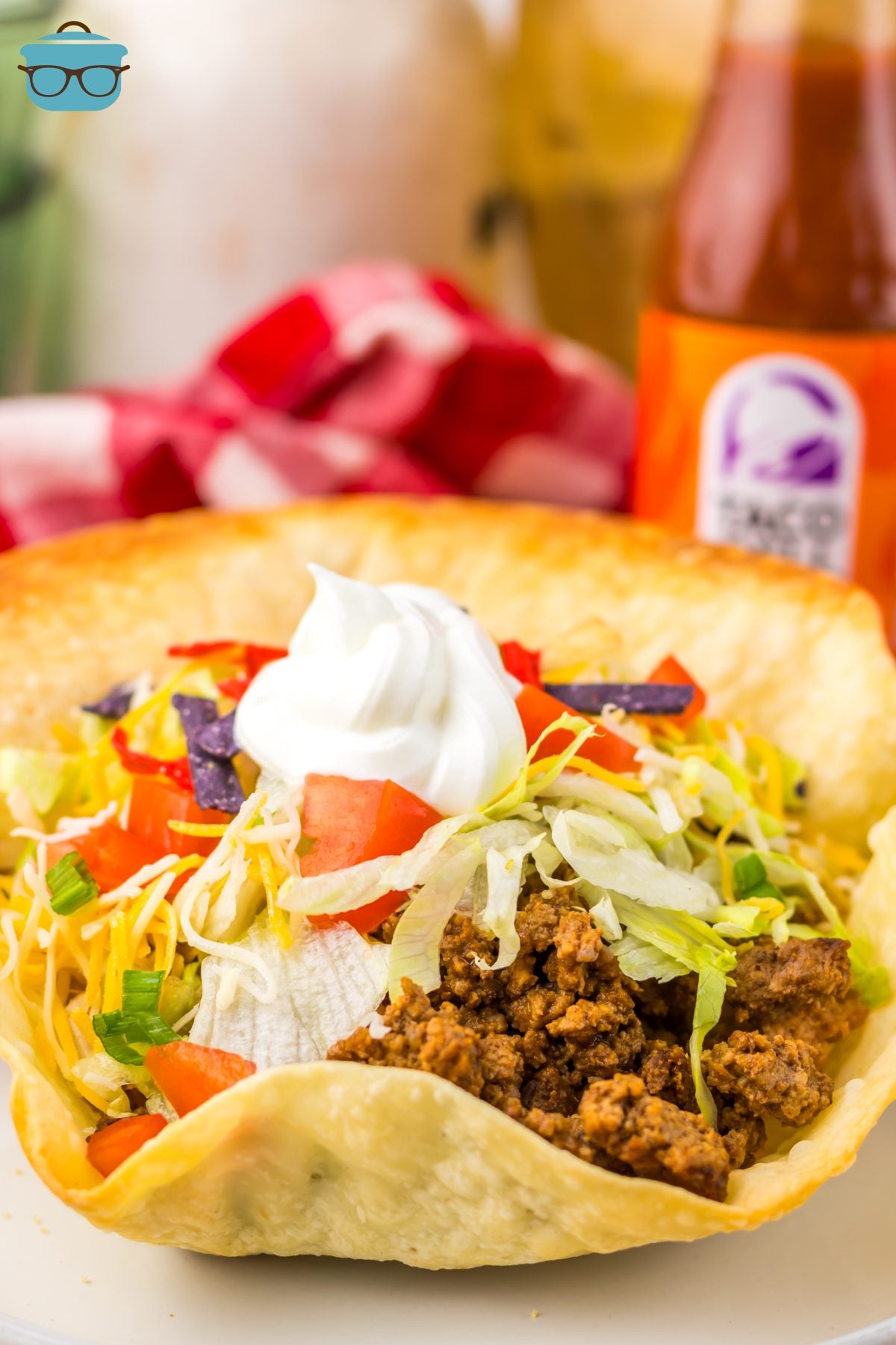 A plate with a Taco Bell Taco Salad and garnishes. 
