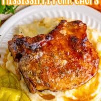 A plate with a Mississippi Pork Chop on a bed of mashed potatoes.