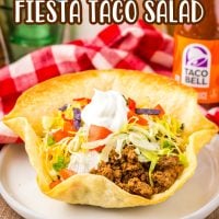 A plate with a hard taco salad bowl with Taco Salad inside.