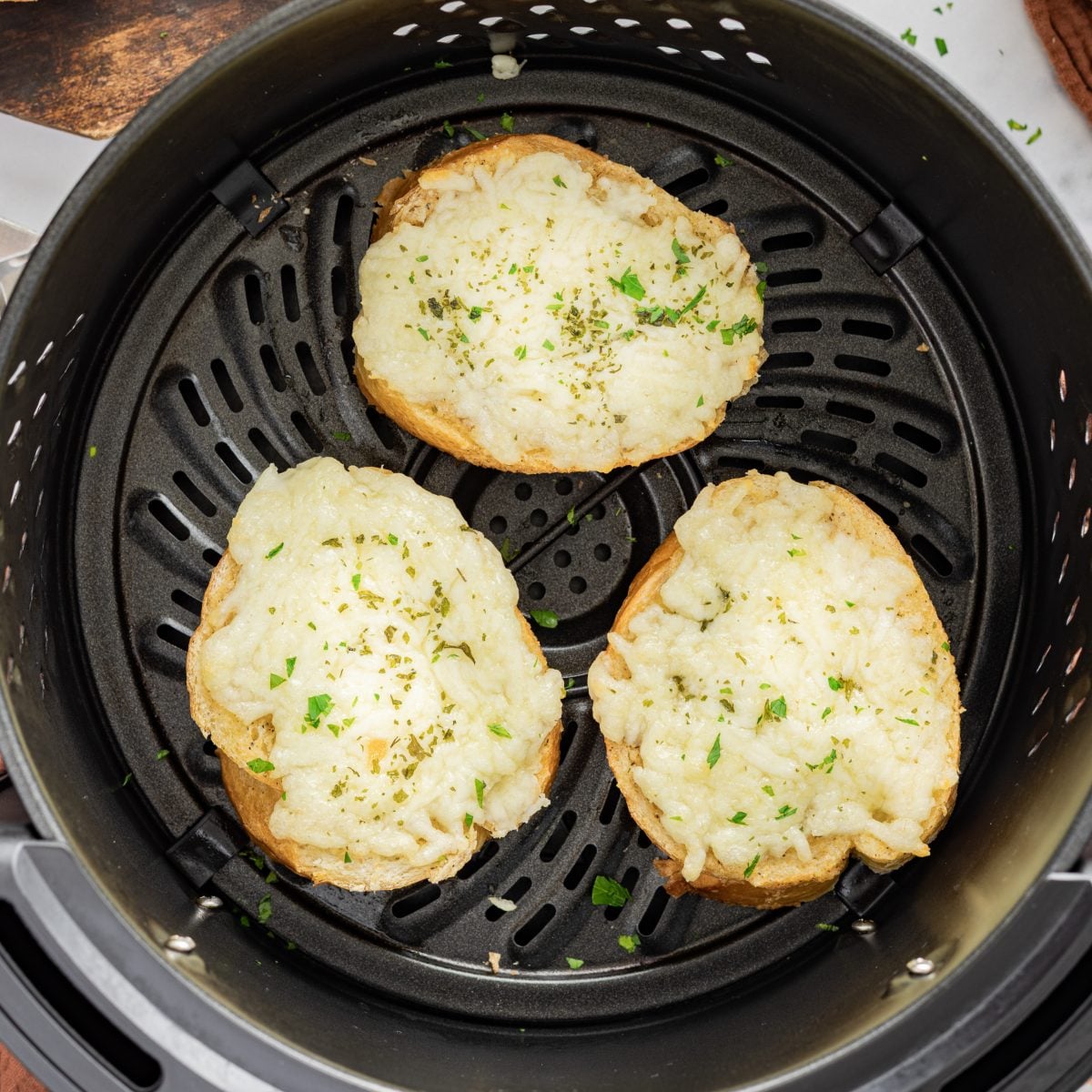 Air Fryer Garlic Cheese Bread shown in an air fryer basket.